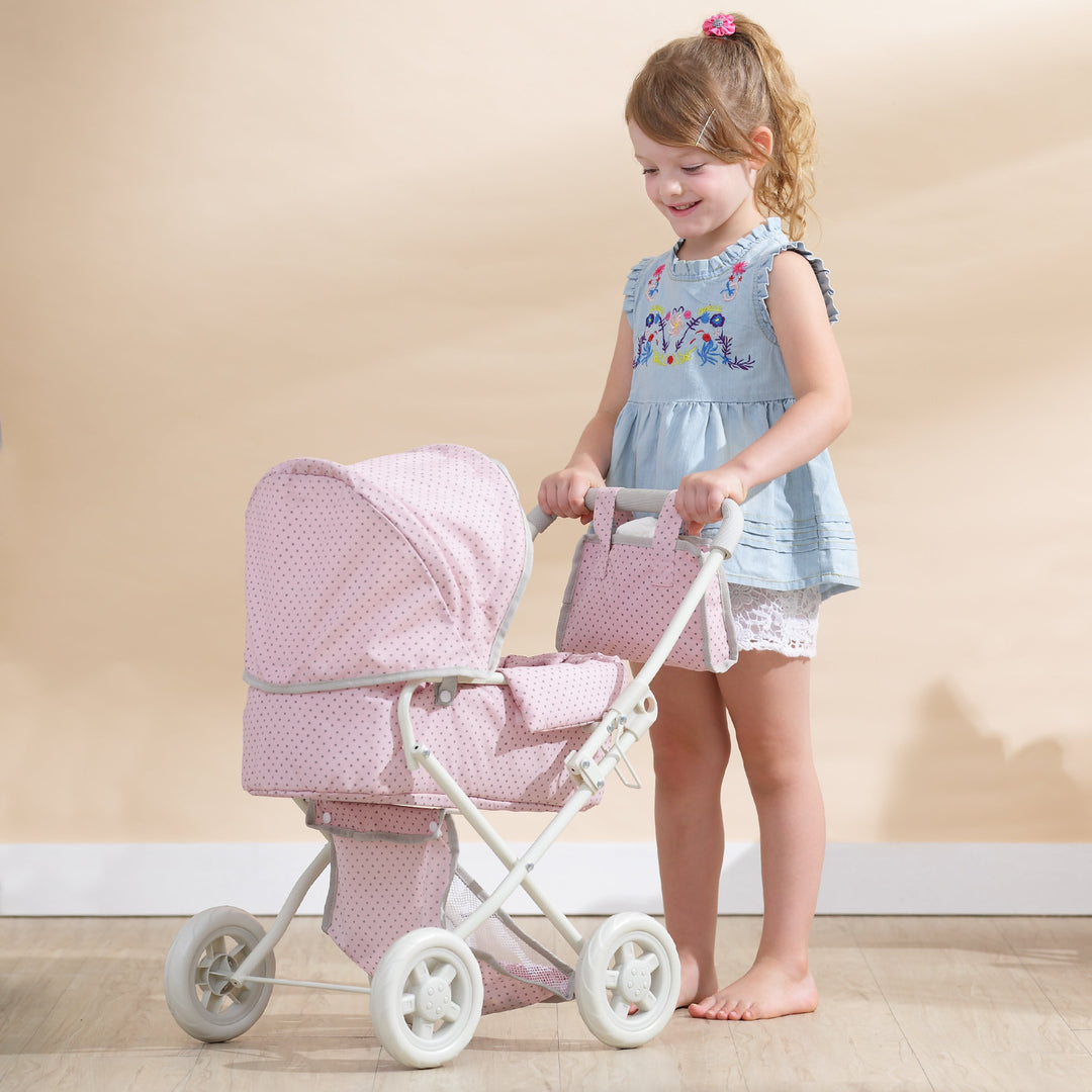 A little girl in a blue dress is pushing a pink dot stroller