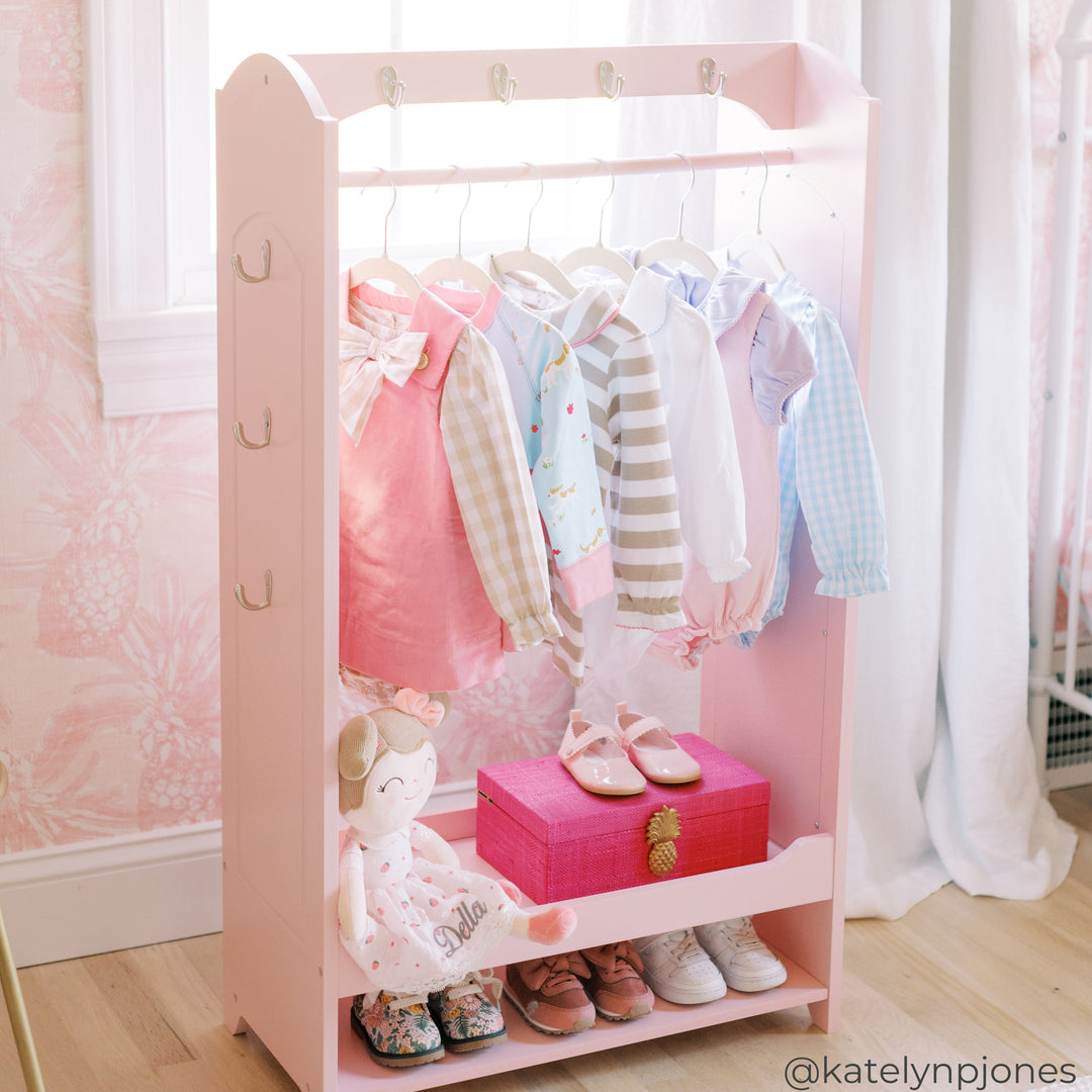 A pink kids Clothing Rack with shelf