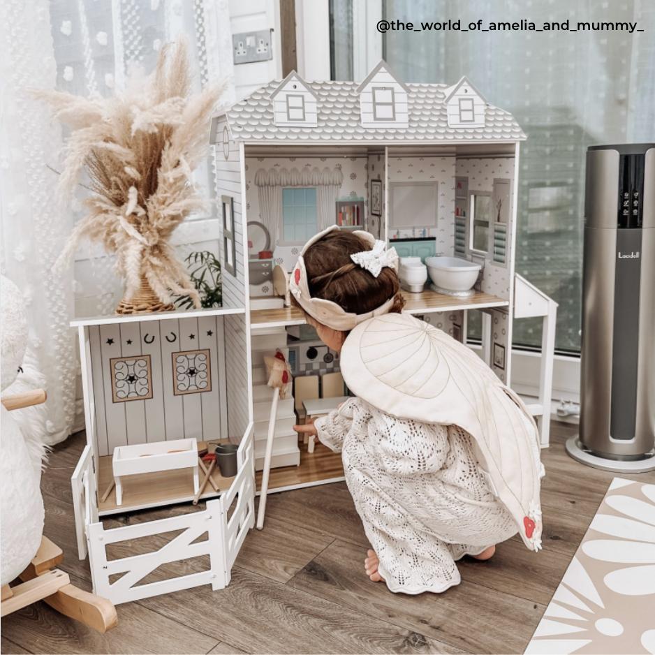 Girl playing with two-story Doll House.