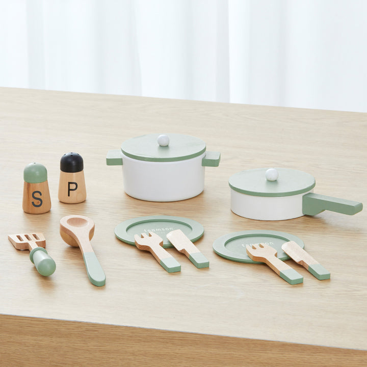 A kitchen playset with a pot, pan, plates, flatwear, spatulas, and seasoning bottles