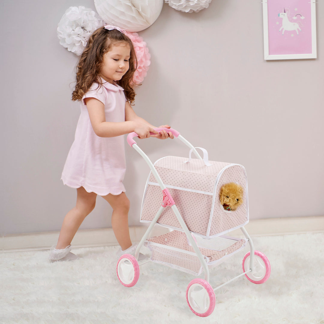 A young girl in a pink dress pushes a toy stroller with a small dog peeking out from the carrier. The room is decorated with pink and white accents.
