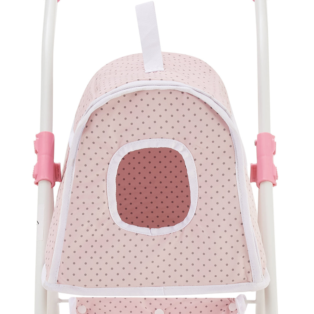 A pink polka dot doll stroller canopy with an oval-shaped window and white trim. The stroller frame features pink accents.
