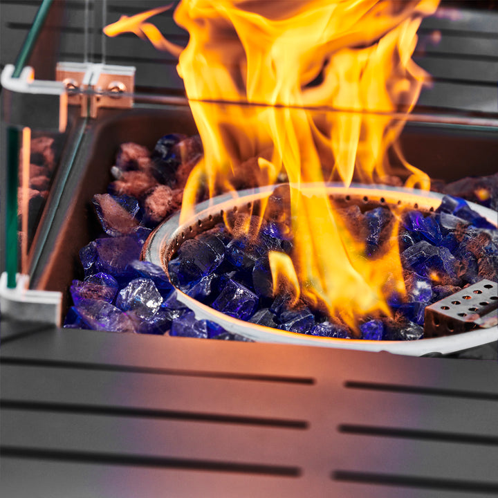 Close-up of a fire burning from a gas ring on blue lava rocks