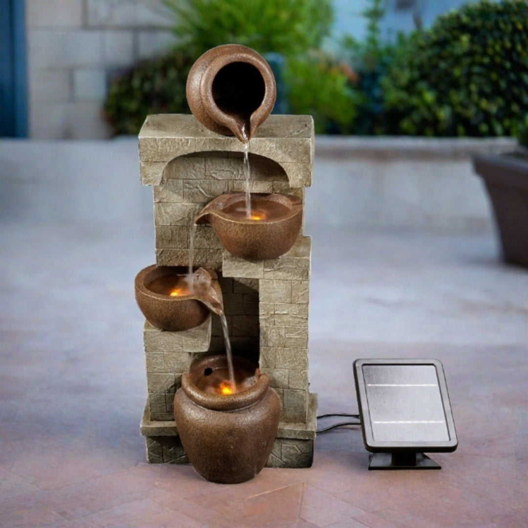 A cascading pots solar-powered water fountain  illuminated from below the water.