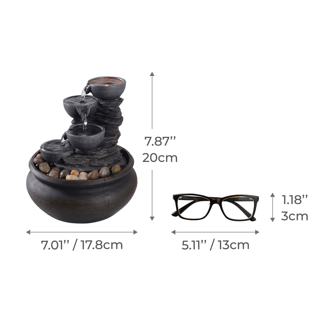 Dimensional graphic of a tabletop water fountain in inches and centimeters compared to a pair of eyeglasses