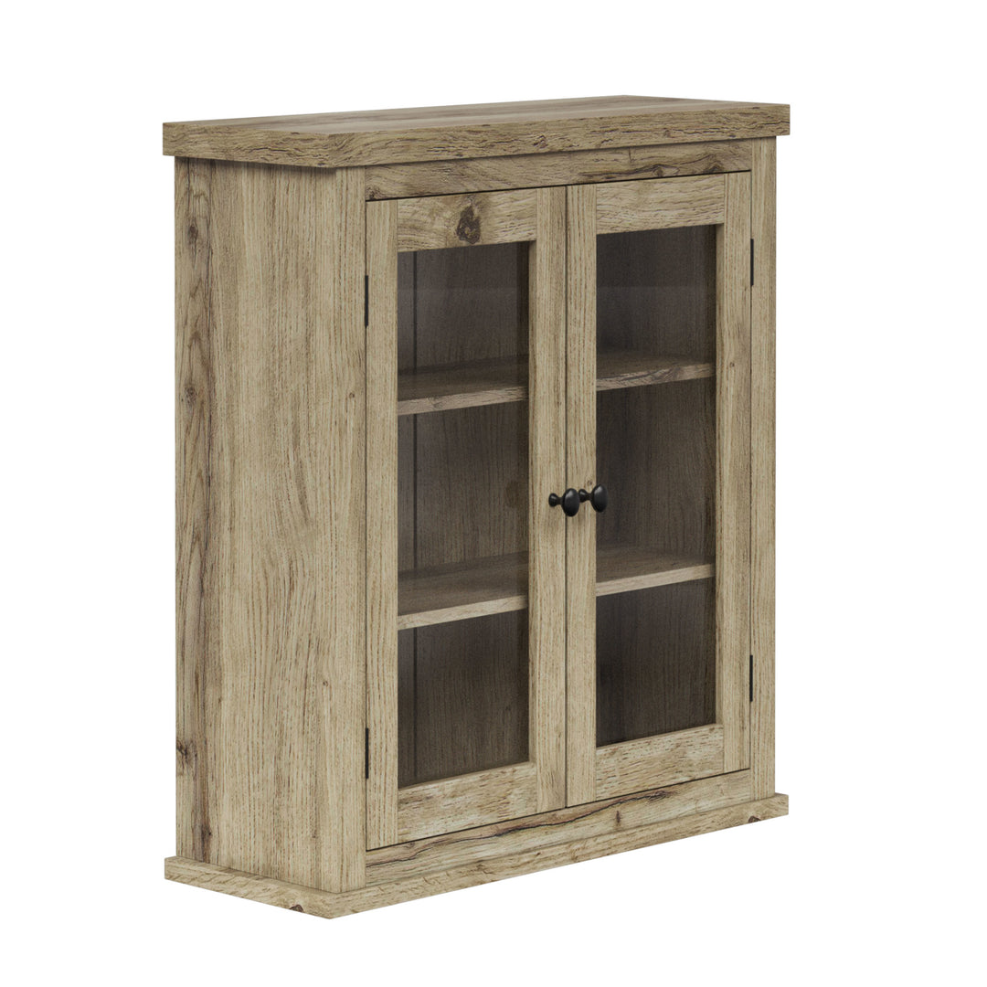 Side view of a light oak finished two-door wall cabinet with glass panels.