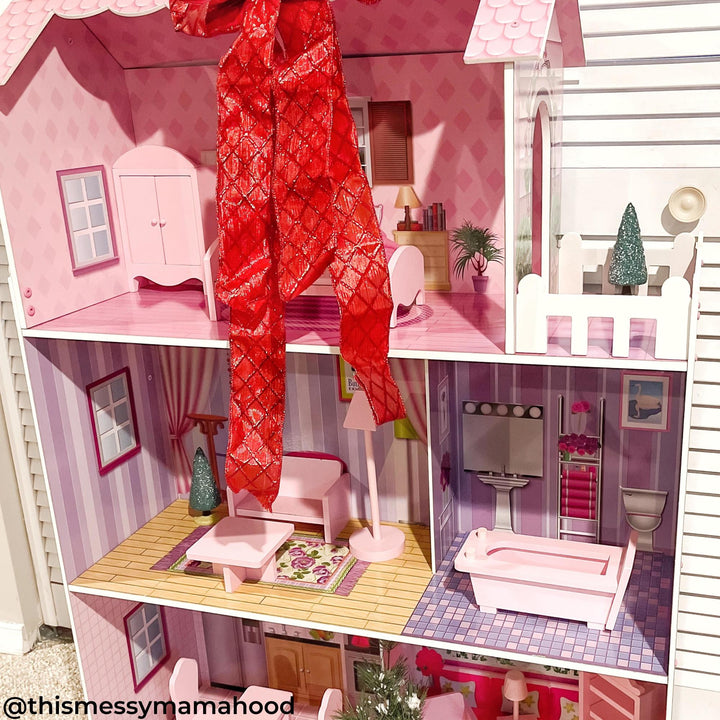 A view of a dollhouse with detailed interior and pink furniture