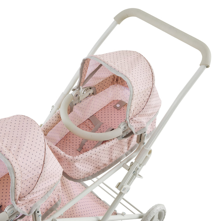 A top view of one of the bassinets pink with gray polka-dotted material and white framework