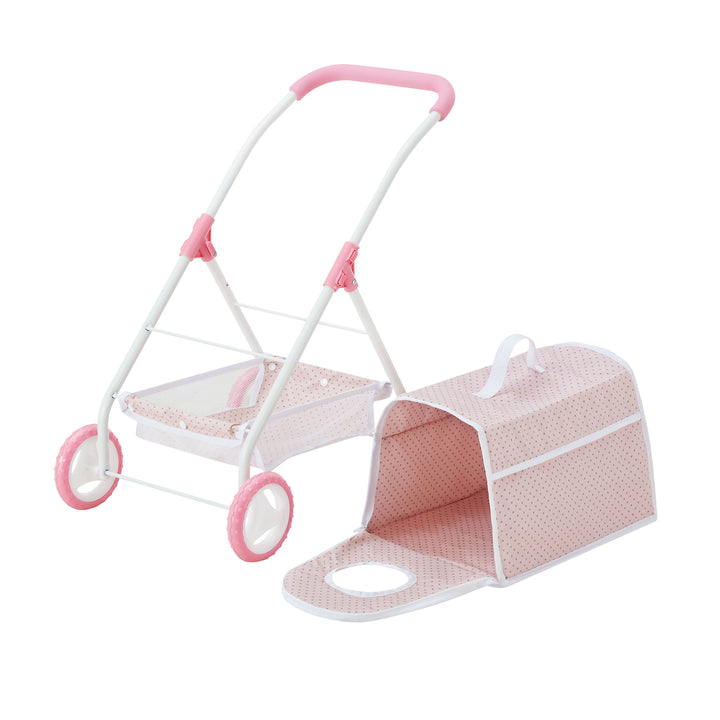 A pink and white toy stroller with a detachable polka dot fabric carrier, featuring a handle and an open front entry.
