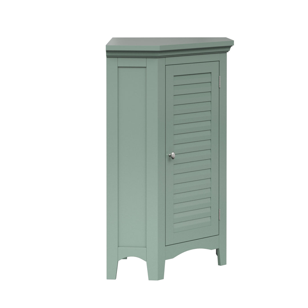 Side view of a sage green corner floor cabinet with silver knobs and two faux louvered doors.