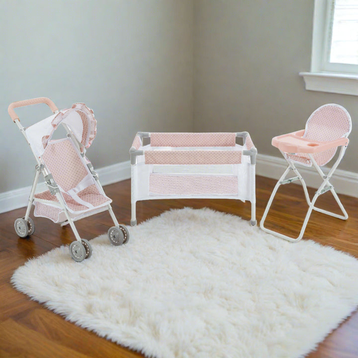 A three-piece child's nursery set in pink and white consisting of a stroller, crib and highchair