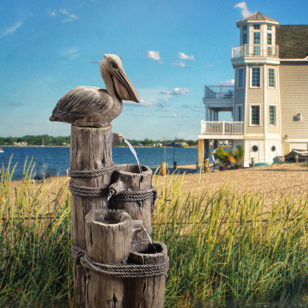 Pelican fountain next to a summer beach house.