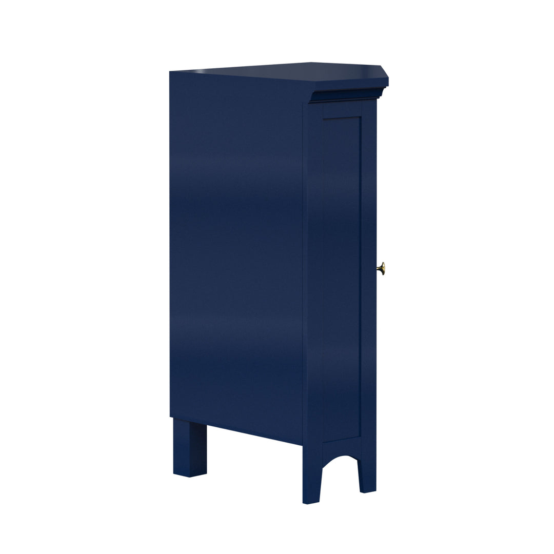 A navy blue corner floor cabinet with gold knobs and two faux louvered doors from the back and side.