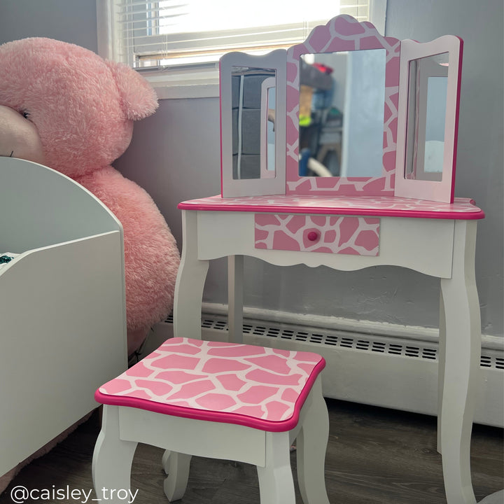 A white vanity with pink giraffe print in a gray playroom