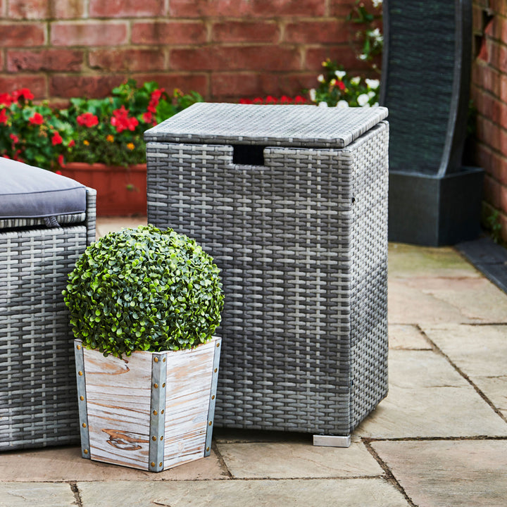 The gray wicker tank cover is shown next to outdoor decor, hiding the propane tank.