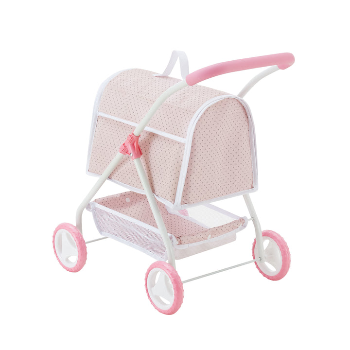 A small, pink and white polka-dotted toy stroller with a canopy, four wheels, and a basket underneath the seating area.
