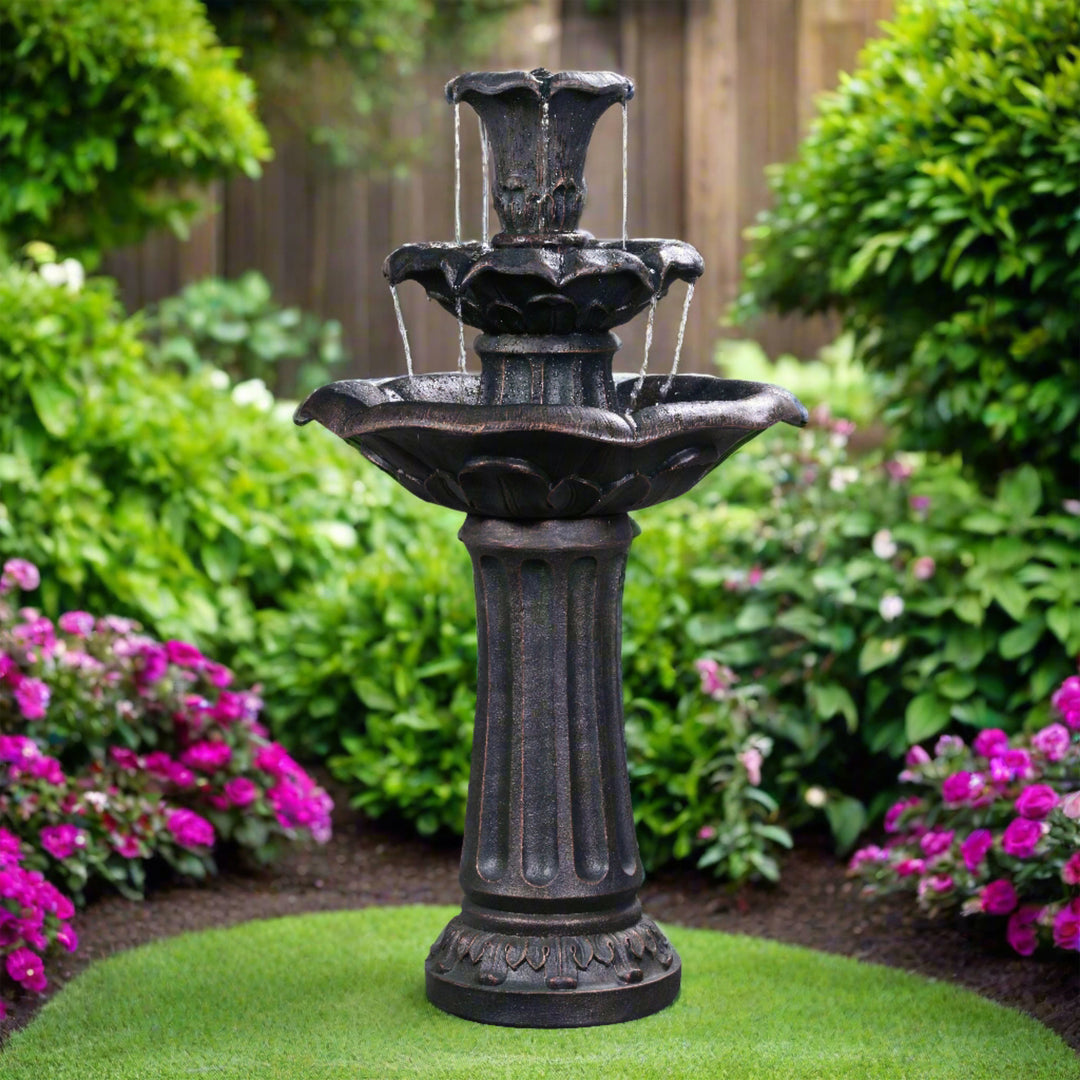 Brass lily fountain in a lush garden with purple flowers