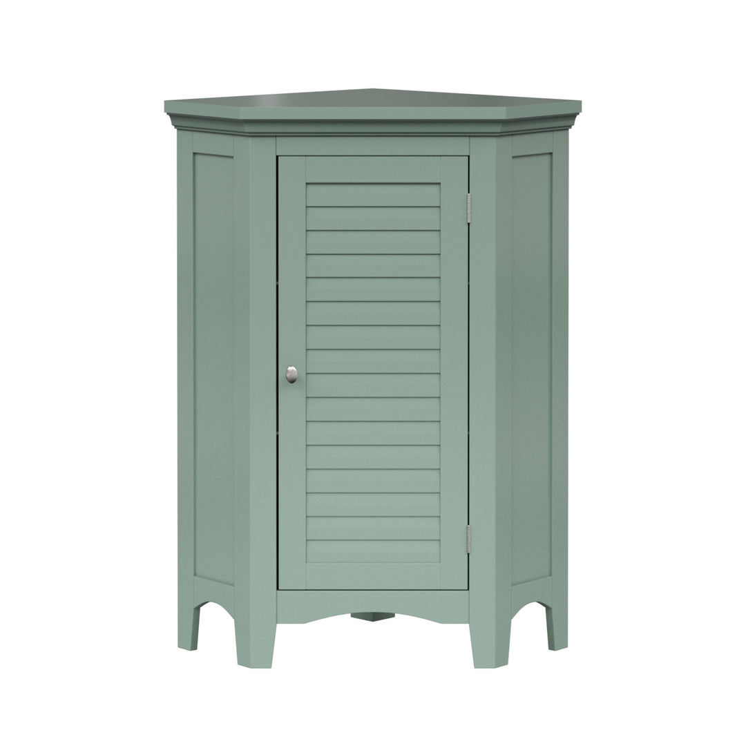 A sage green corner floor cabinet with silver knobs and two faux louvered doors.