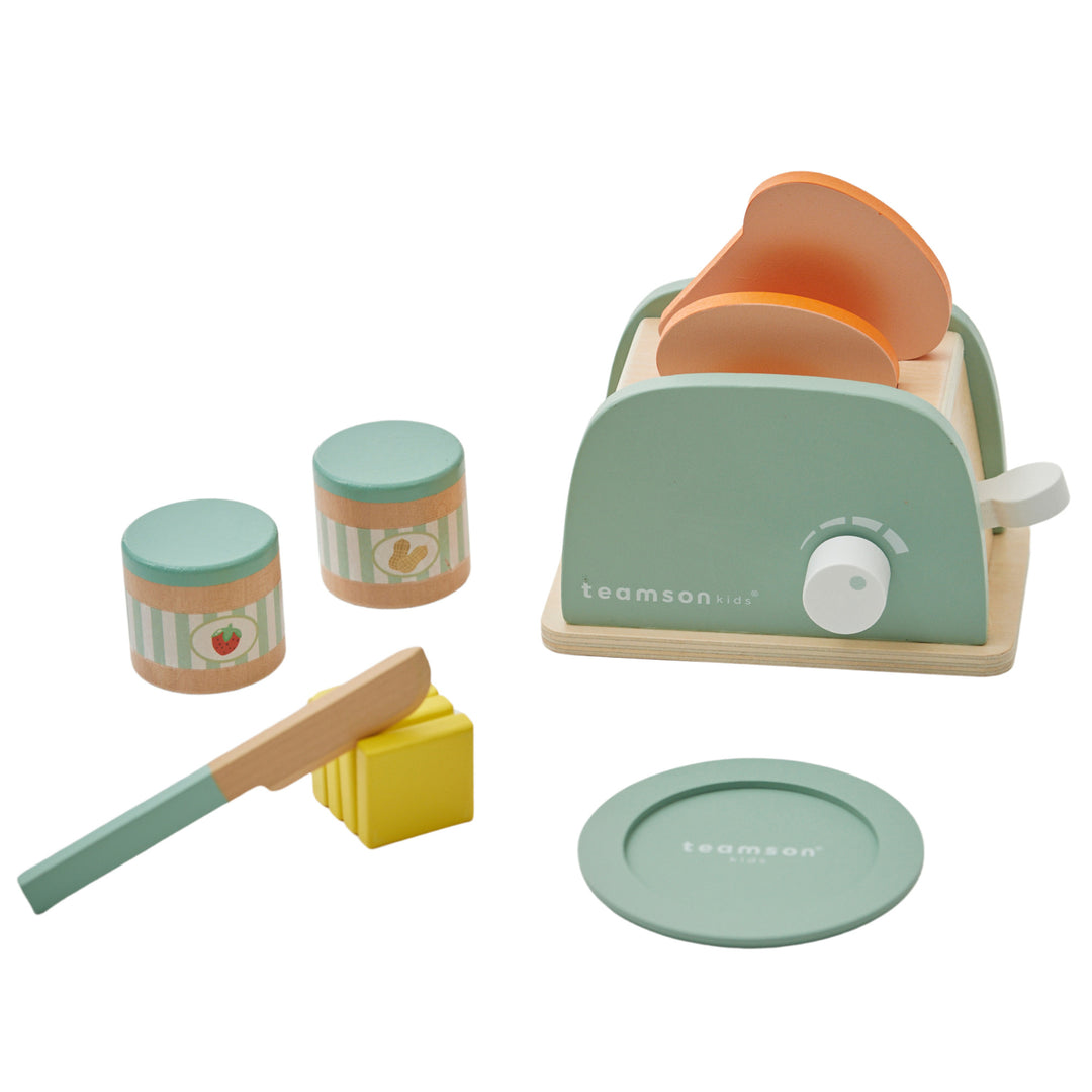 A play toaster with pretend bread, butter pats, knife, jars of spread and a plate