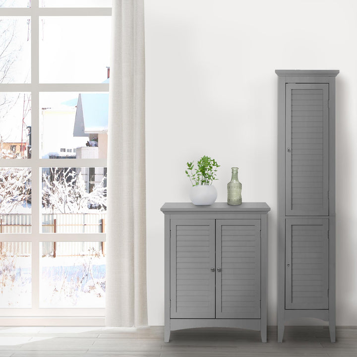 A tall gray linen cabinet and matching floor cabinet next to a large window