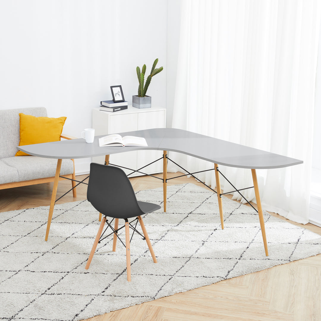 L-shaped desk with a black chair next to a sofa with a yellow pillow