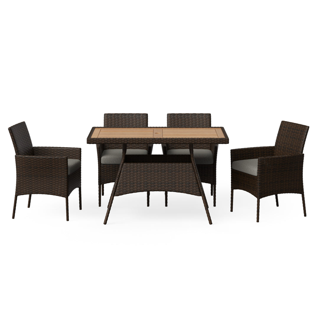 A dining set with a table and four chairs made of brown PE rattan with a wood tabletop