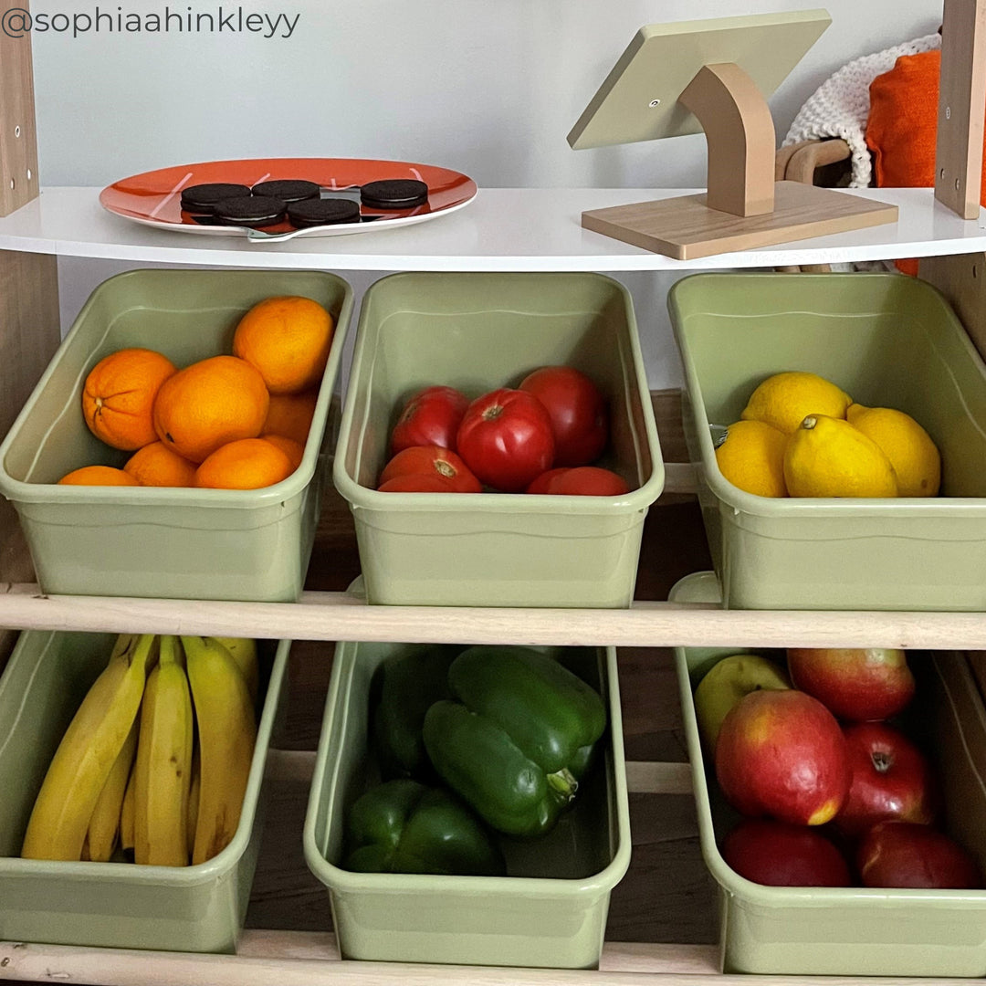 Close-up of a child's pretend market stand with real fruits and vegetables