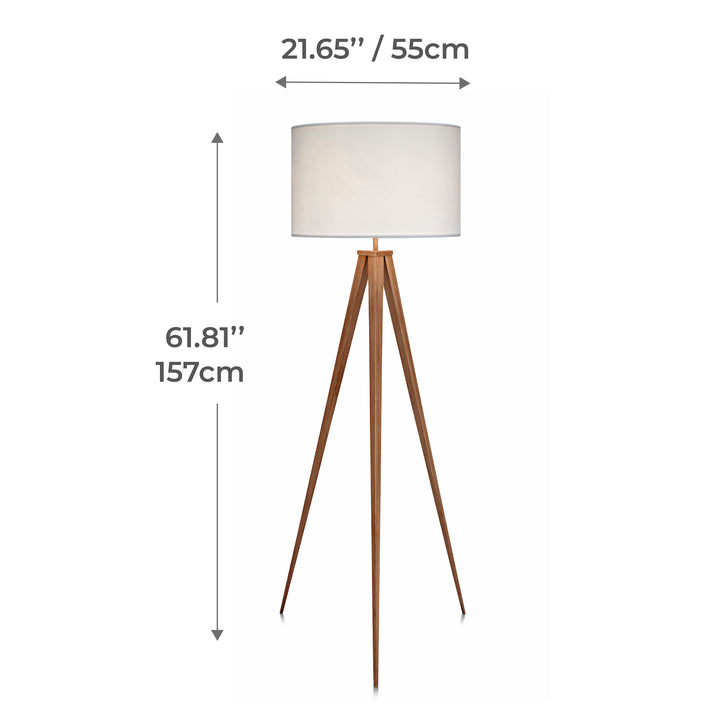 A tripod style floor lamp with natural wood finished legs and a white faux linen lampshade with dimensions in inches and centimeters