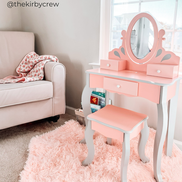 A pink and gray vanity set on a fuzzy pink rug