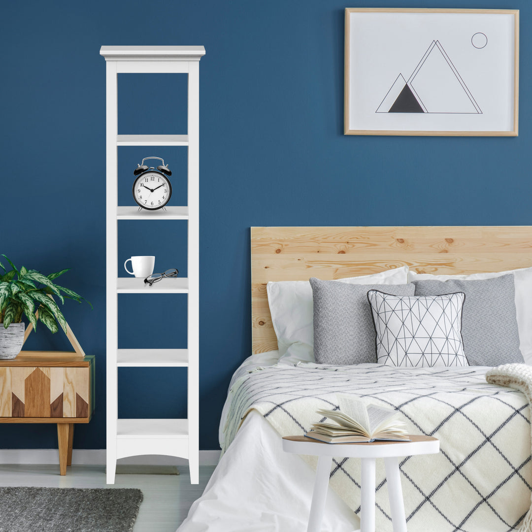 A 5-tier open shelving unit next to a bed with a clock on it