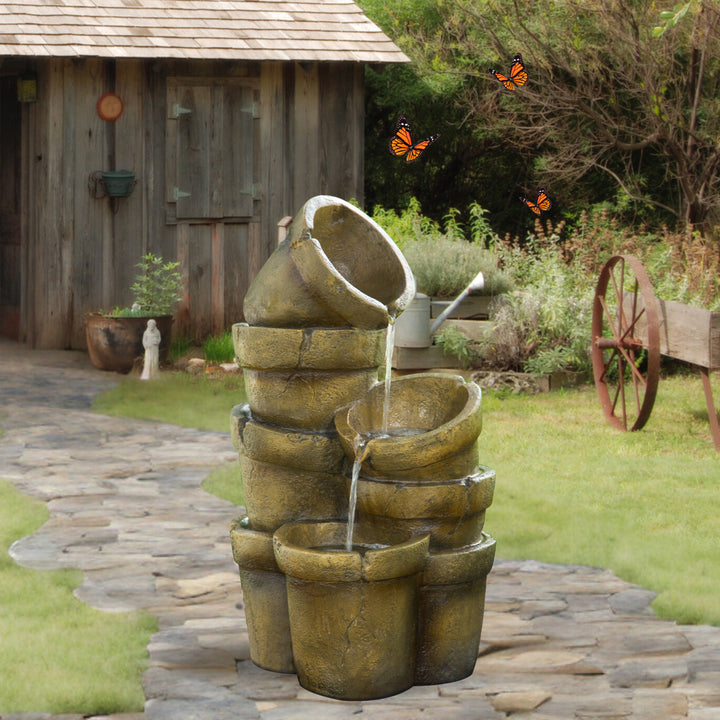 Rustic pots overflow with water in a backyard