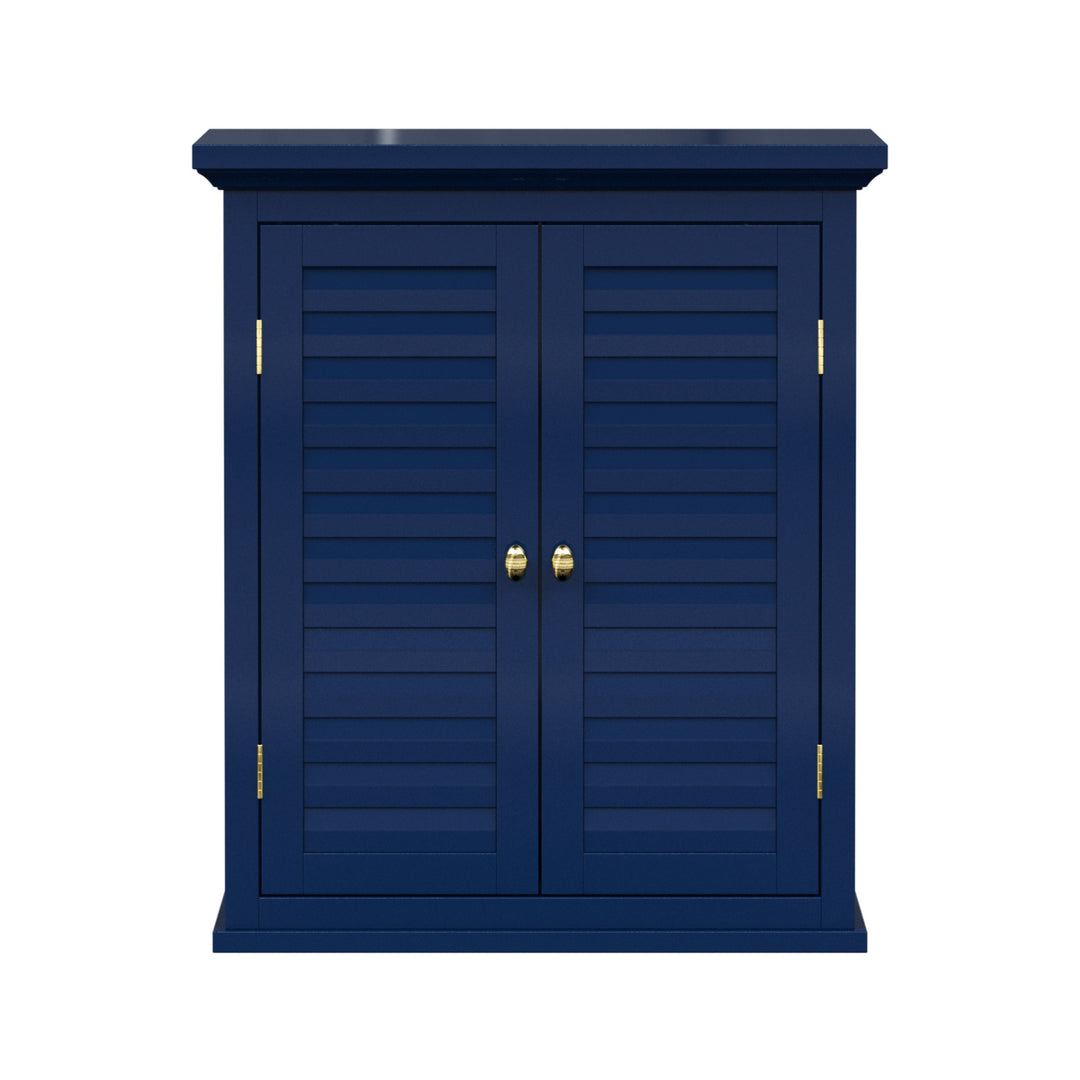 Navy blue wall cabinet with two faux louvered doors and gold hardware.