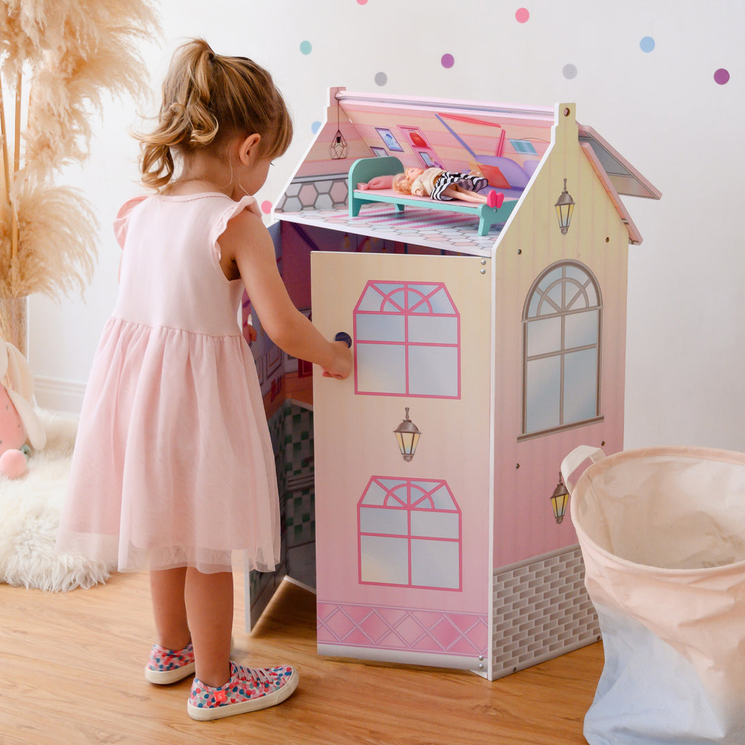 A little girl opening the three-story dollhouse.