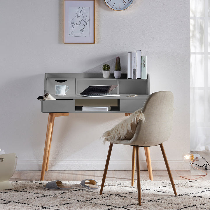 A Teamson Home Creativo Wooden Writing Desk with Storage in a room with a chair and a clock.