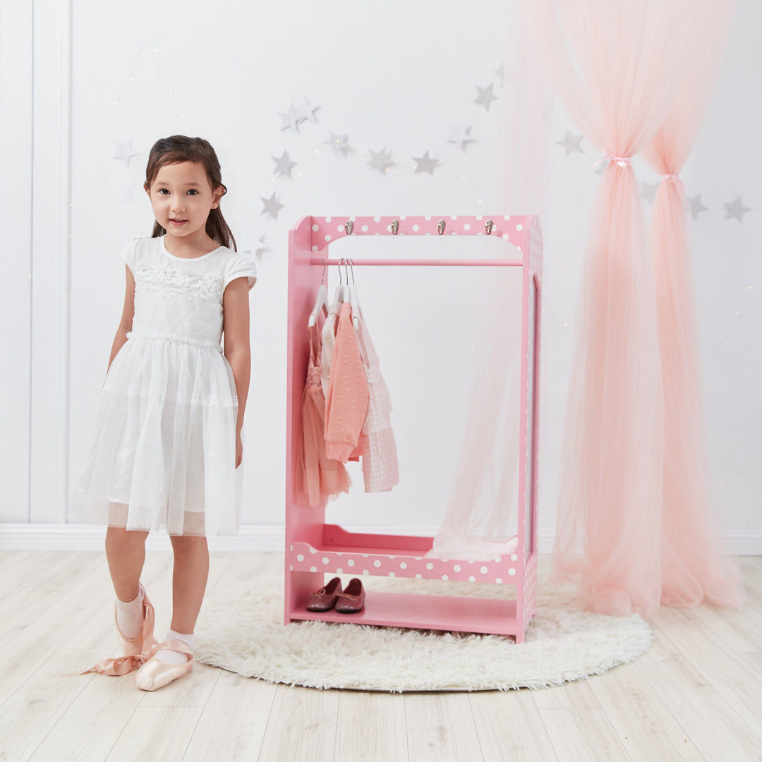 A girl standing next to a Polka Dots Clothing Rack with Storage