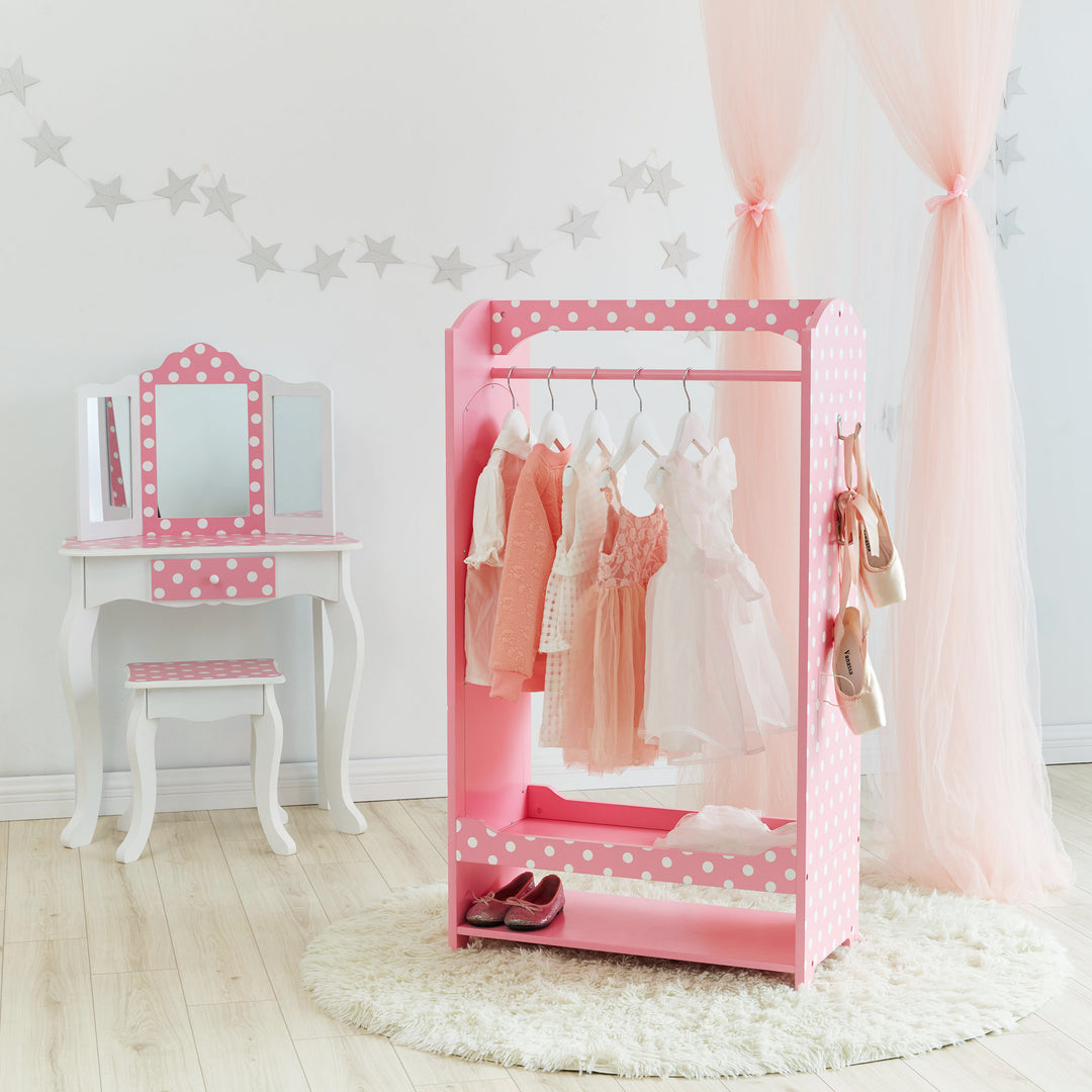 Dresses hanging in a Polka Dots Clothing Rack with Storage next to a white vanity