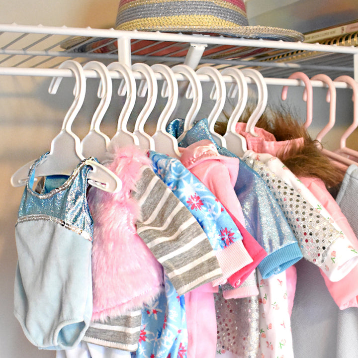 A photo of different Sophia's 18" doll outfits hung on the white clothes hangers in a real life closet.