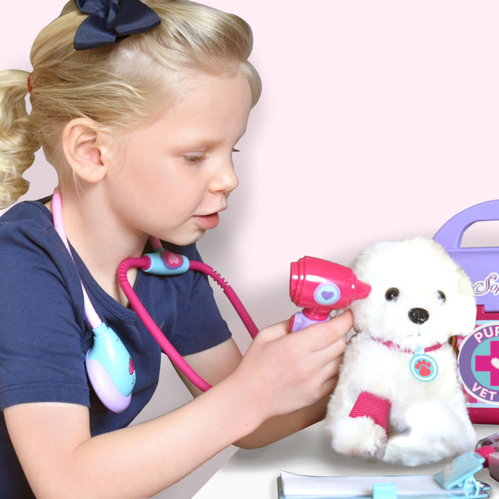 A little girl looks inside the puppy's ear with the otoscope.