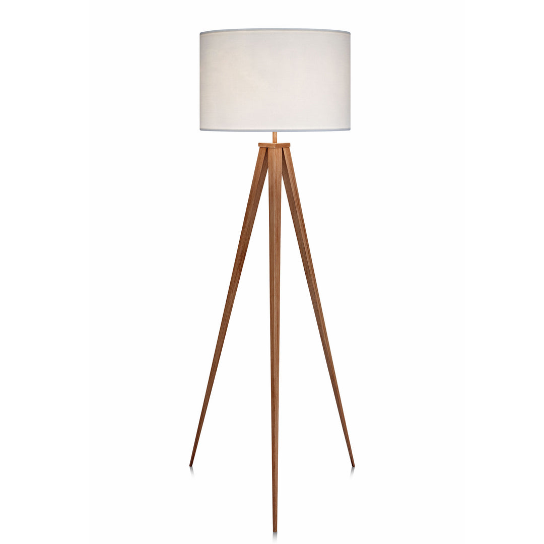 A tripod style floor lamp with natural wood finished legs and a white faux linen lampshade