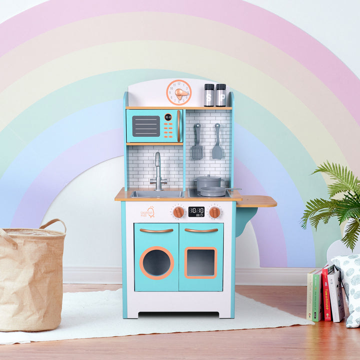 A play kitchen in white and aqua blue with gold accents, a faux tile backsplash and faux wood countertop.