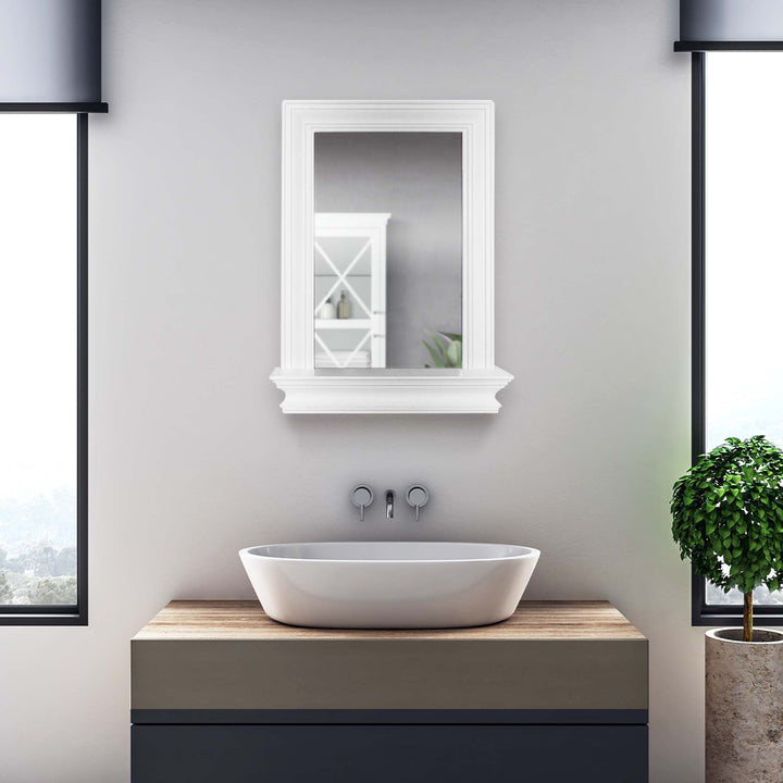 A Teamson Home Stratford Wall Mirror with Shelf, White, in a sleek, gray bathroom.