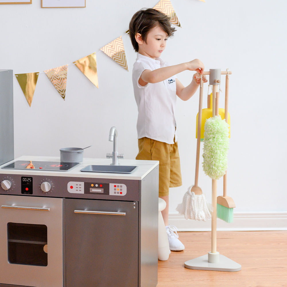 Child playing with a Teamson Kids 6 Piece Little Helper Cleaning Set in a playroom.