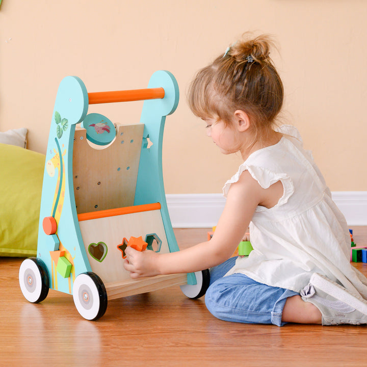 A little girl pushes an orange star through the shape sorter.