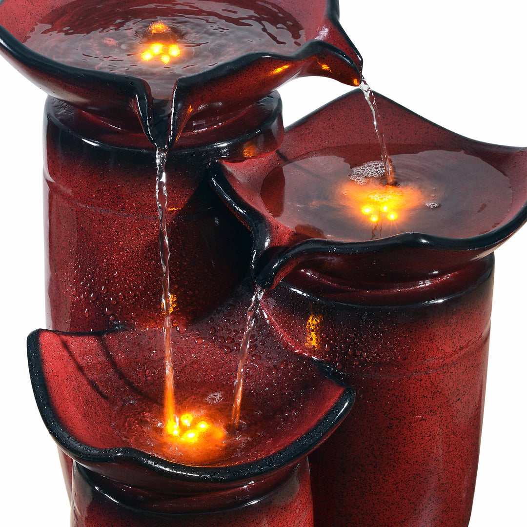 A close-up of the top of the fountain to see the lights glowing beneath the water of the Teamson Home Outdoor 3-Tier Glazed Pot Floor Fountain with LED Lights, Red