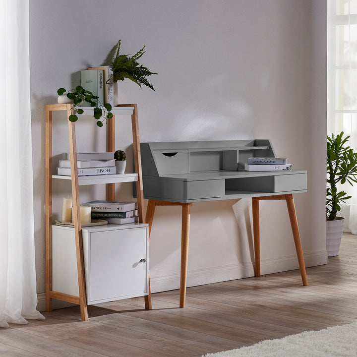 A Teamson Home Creativo Wooden Writing Desk with Storage, Light Gray/Natural with a bookcase and a plant next to it.